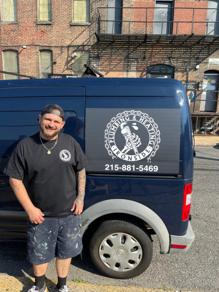 Owner of Ironside Plumbing & Heating standing beside the company service van