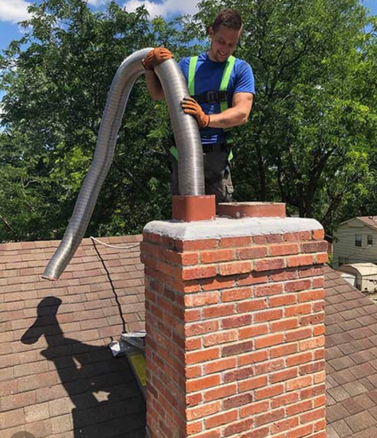Ironside technician installing a chimney liner on a rooftop chimney